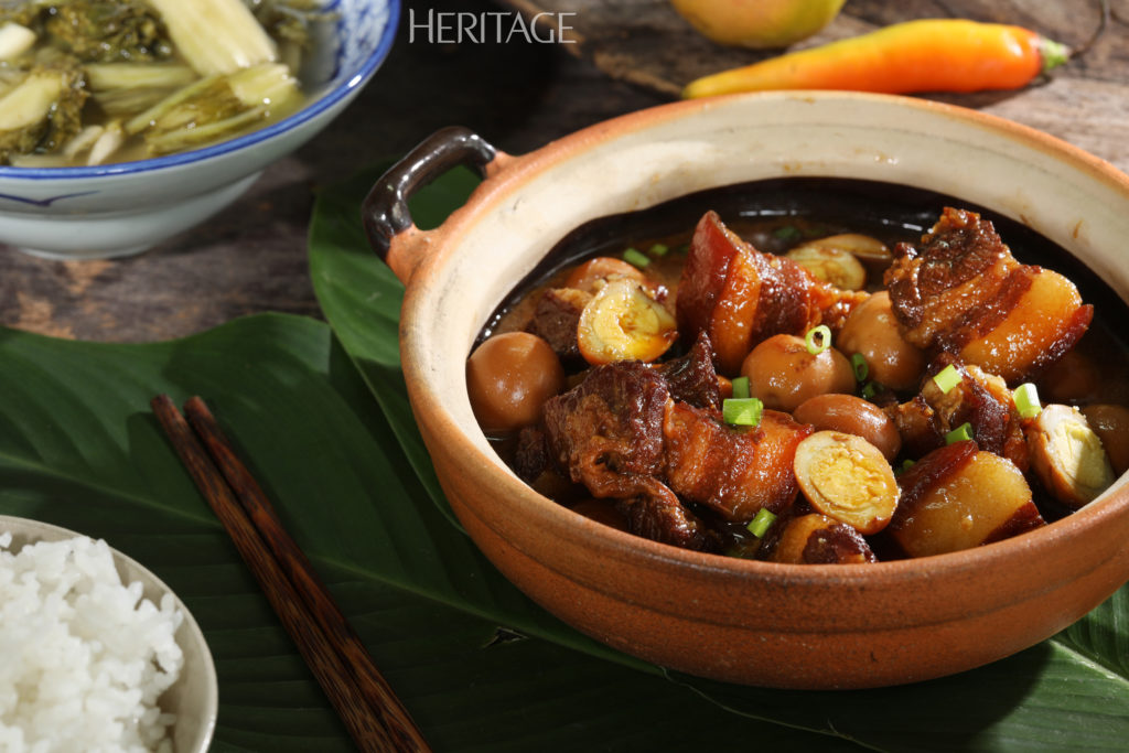 Đĩa gà kho nghệ với ớt lát, đặt cạnh bát cơm