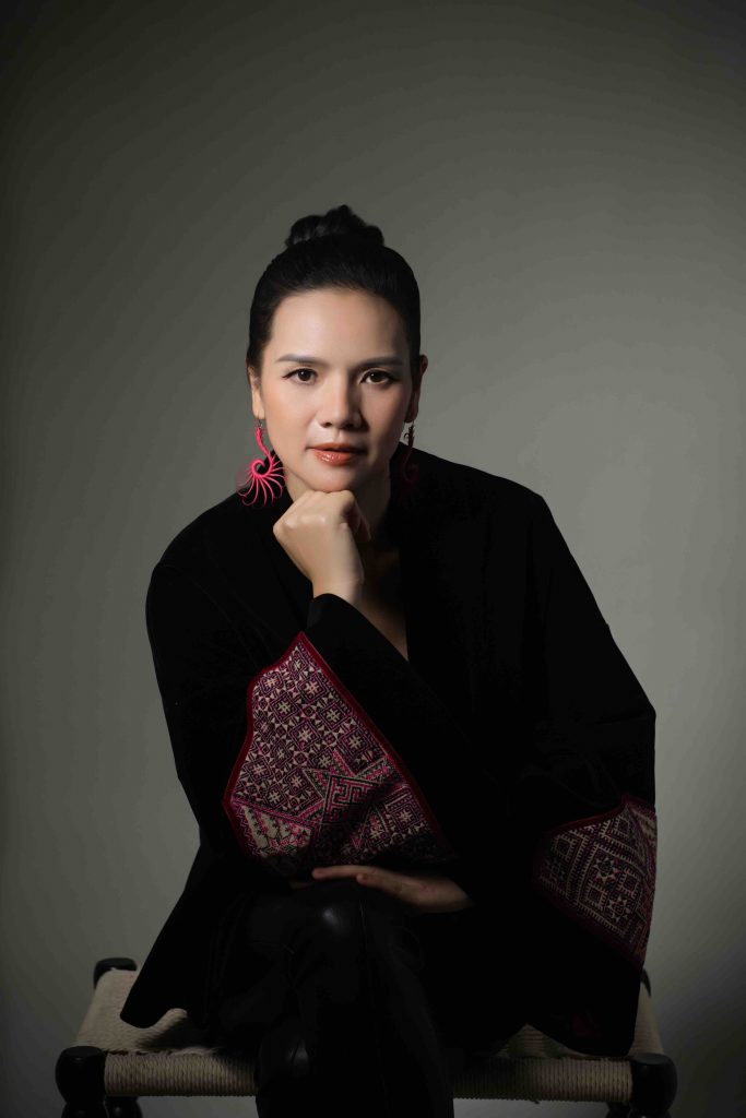 NTK Ngọc Anh diện &aacute;o d&agrave;i đen th&ecirc;u họa tiết đỏ nổi bật tr&ecirc;n nền x&aacute;m